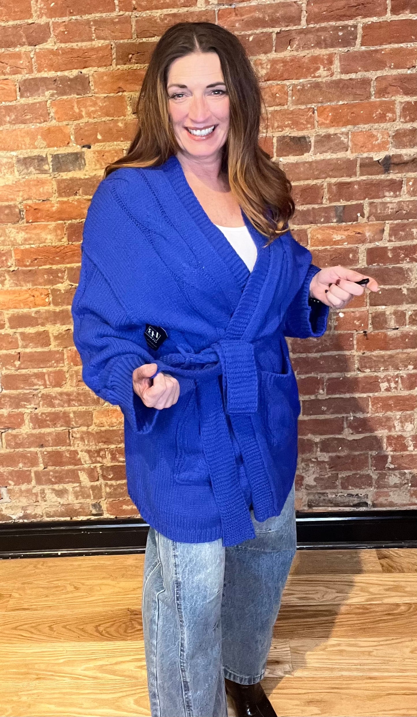 Blue cardigan sweater, relaxed fit, dropped shoulders, long sleeves, open front with waist tie wrap, pockets, kimono silhouette.
