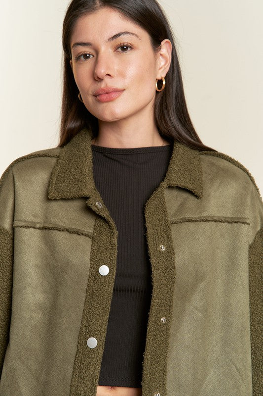Woman wearing a green jacket with a plain background