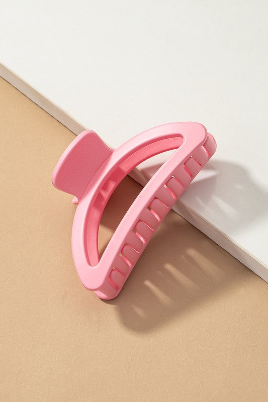 Pink phone holder on a beige surface with a white border