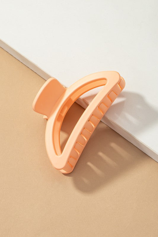 Orange plastic tool on a beige surface with a white background