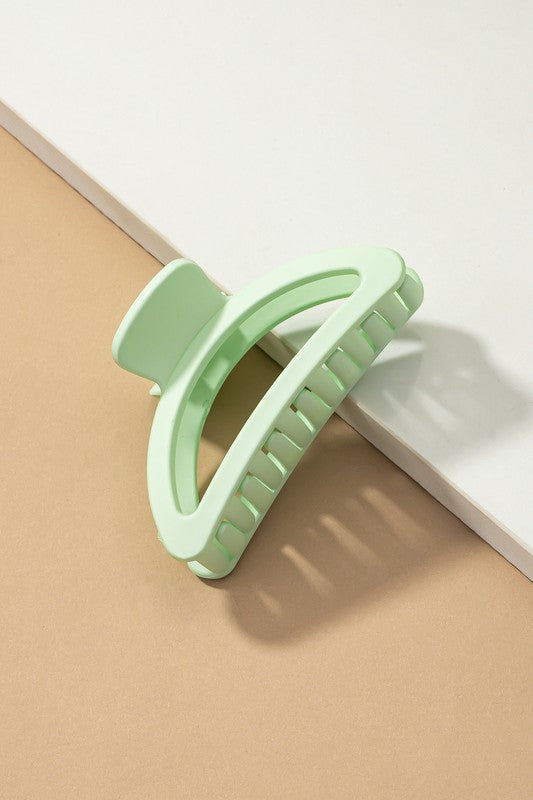 Light green hair clip on a beige and white background