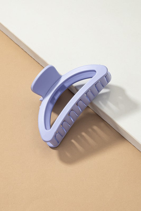Purple hair clip on a beige and white background