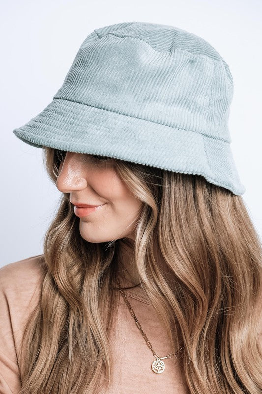 Woman wearing a light blue bucket hat on a white background