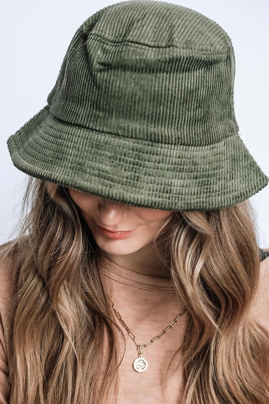 Person wearing a green bucket hat with a plain background