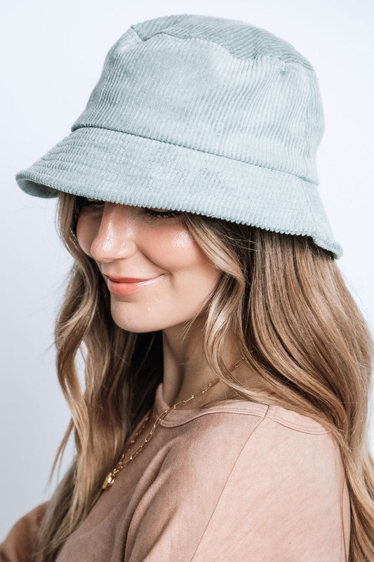 Woman wearing a light blue bucket hat against a white background