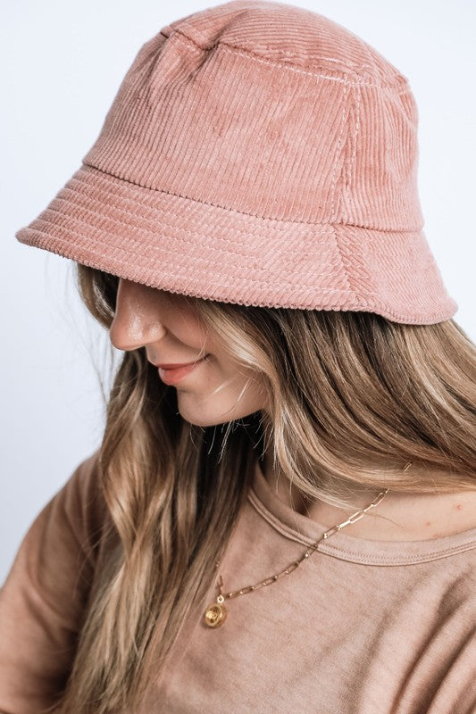 Person wearing a pink bucket hat with a plain background