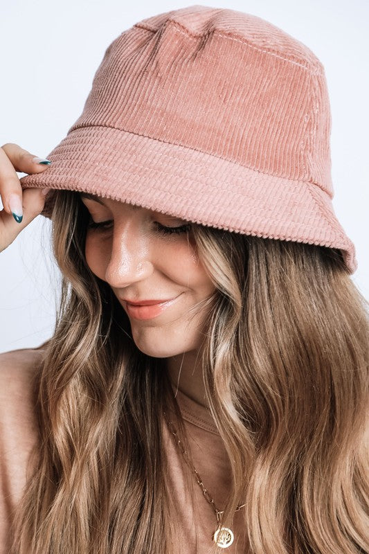 Woman wearing a pink bucket hat with a plain background