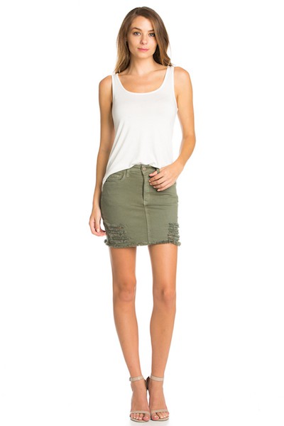 Woman wearing a white tank top and green skirt on a white background