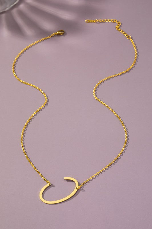 Gold necklace with a unique pendant on a purple background
