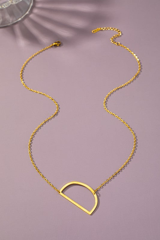 Gold necklace with a unique pendant on a purple background