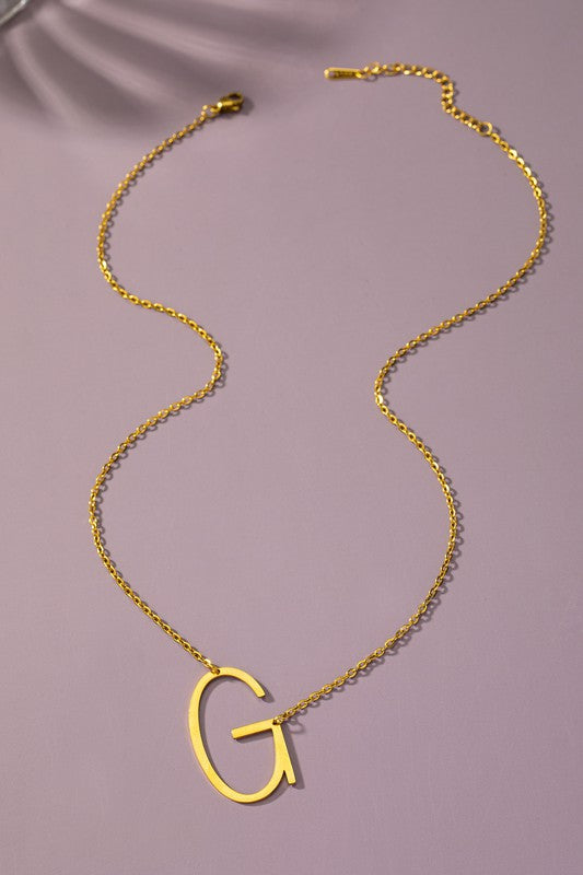 Gold necklace with a 'G' pendant on a purple background