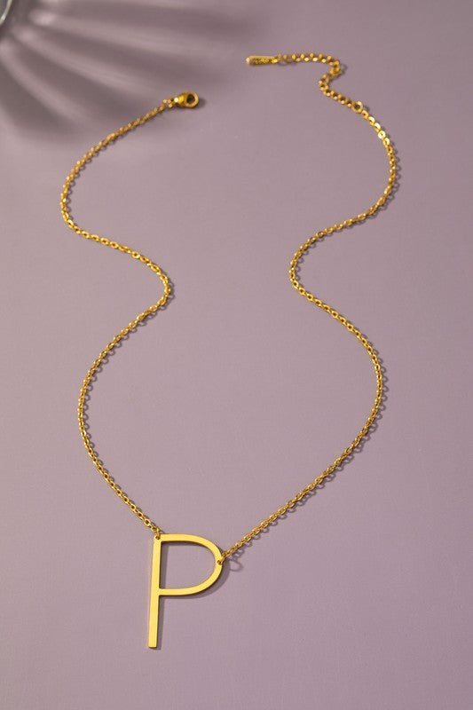 Gold necklace with a 'P' pendant on a purple background