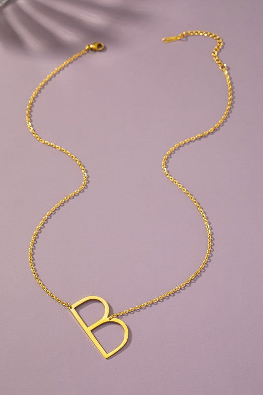 Gold necklace with a unique clasp design on a purple background