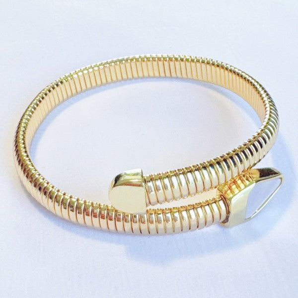 Gold snake-shaped bracelet on a light blue background