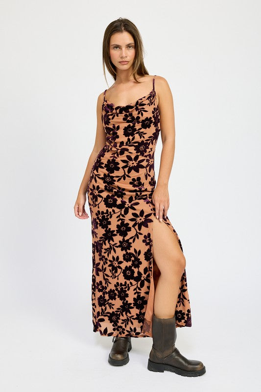Woman wearing a floral dress with a slit on a white background