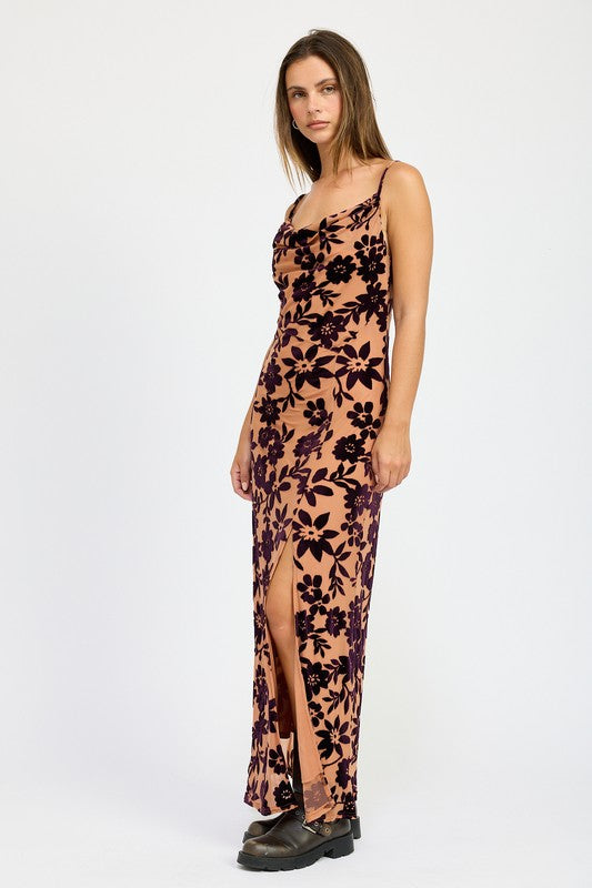 Woman wearing a floral dress with a slit on a white background