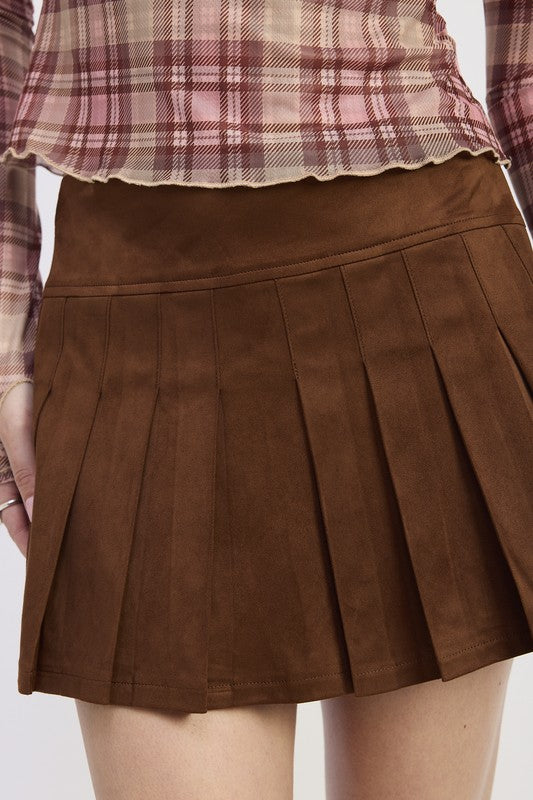Woman wearing a plaid shirt and brown skirt with a yellow bag on a white background