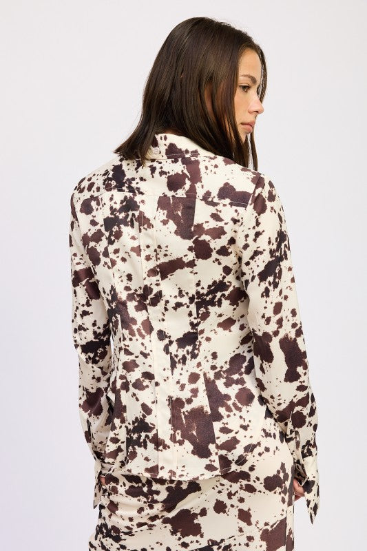 Woman wearing a patterned blouse on a plain background