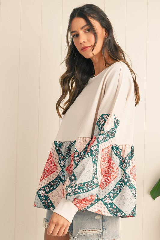 Woman wearing a white top with floral sleeves against a light wooden panel background