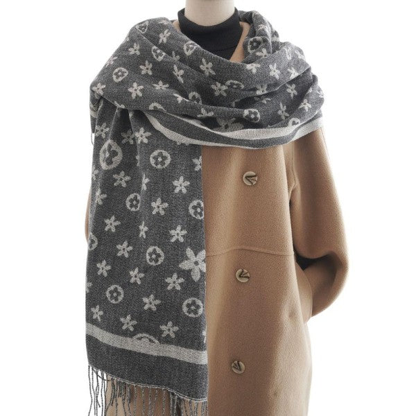 Mannequin wearing a brown coat with a gray patterned scarf on a white background
