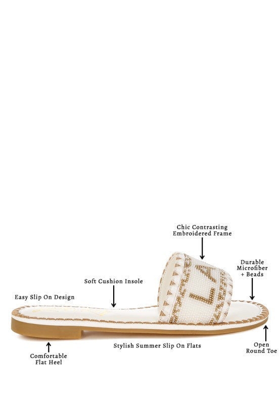 White sandal with brown sole on a white background, featuring text labels about shoe features.