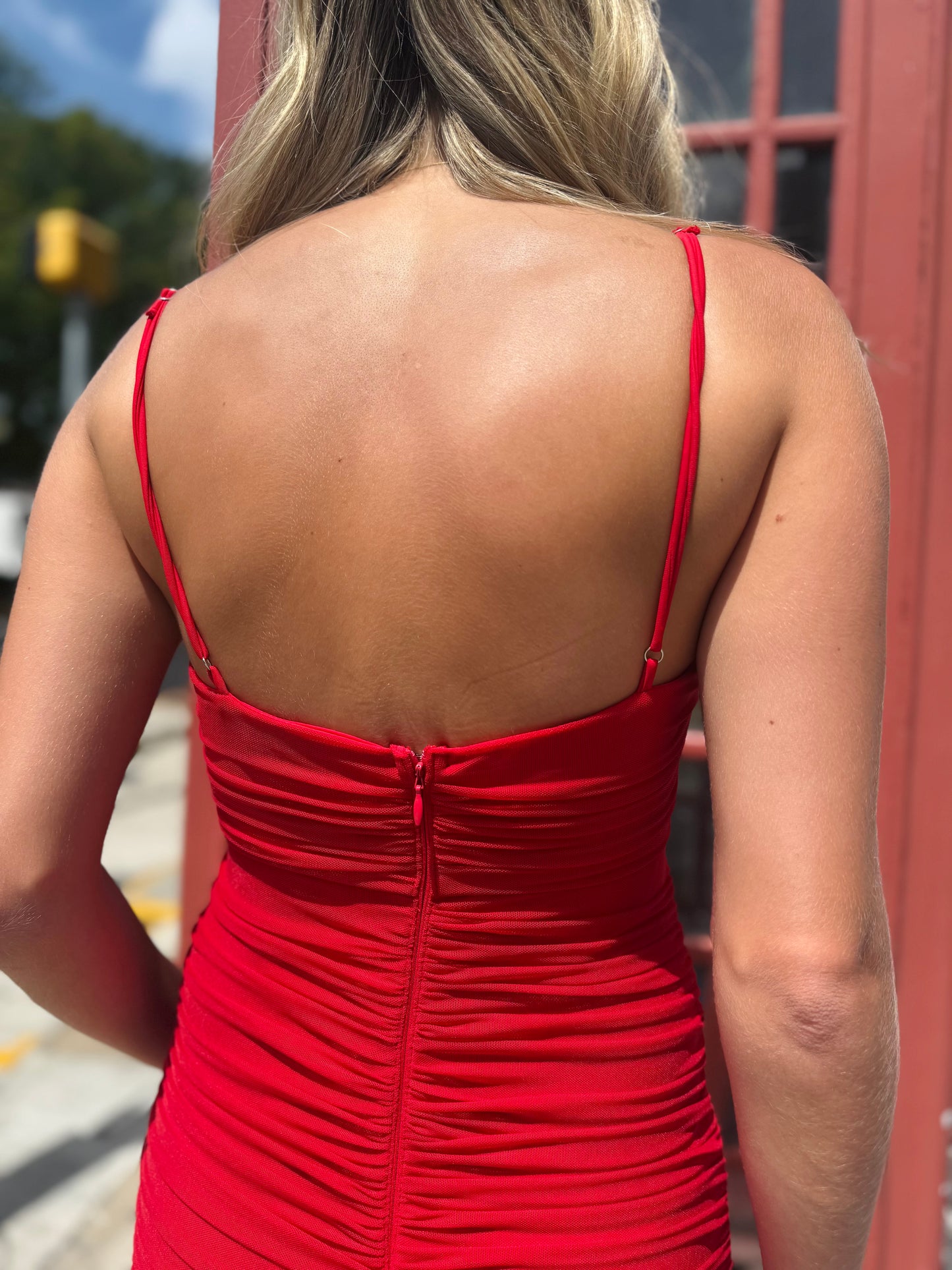Woman wearing a red dress with a blurred outdoor background
