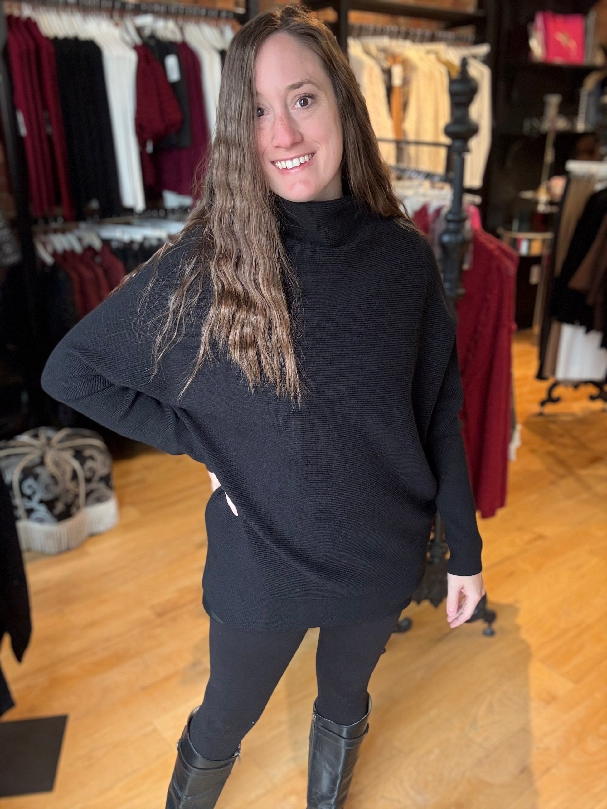 Woman wearing a black turtleneck sweater and leggings in a clothing store.