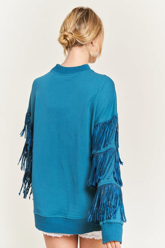 Teal fringed sweater worn by a person on a white background