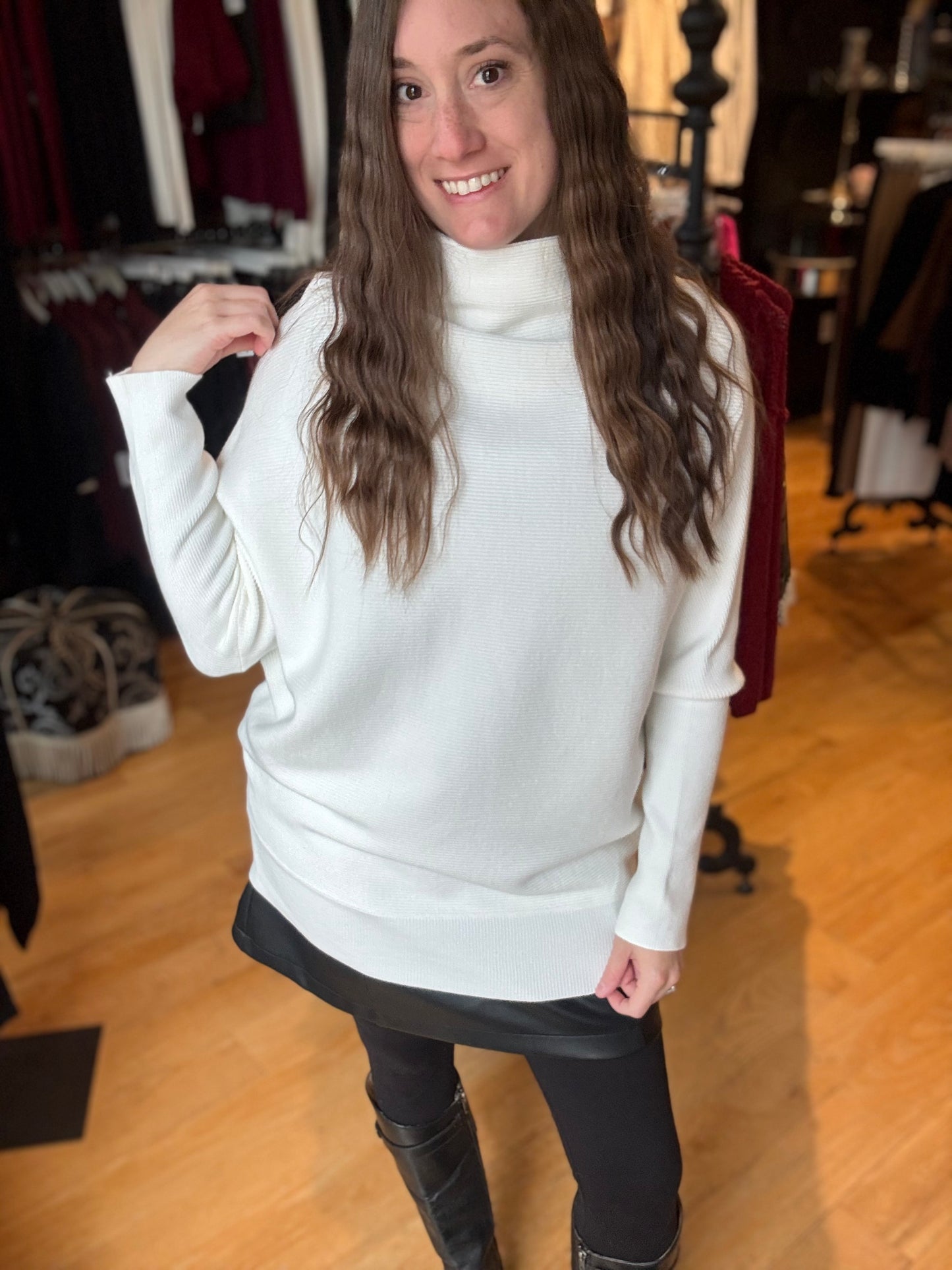 Woman wearing a white sweater in a clothing store