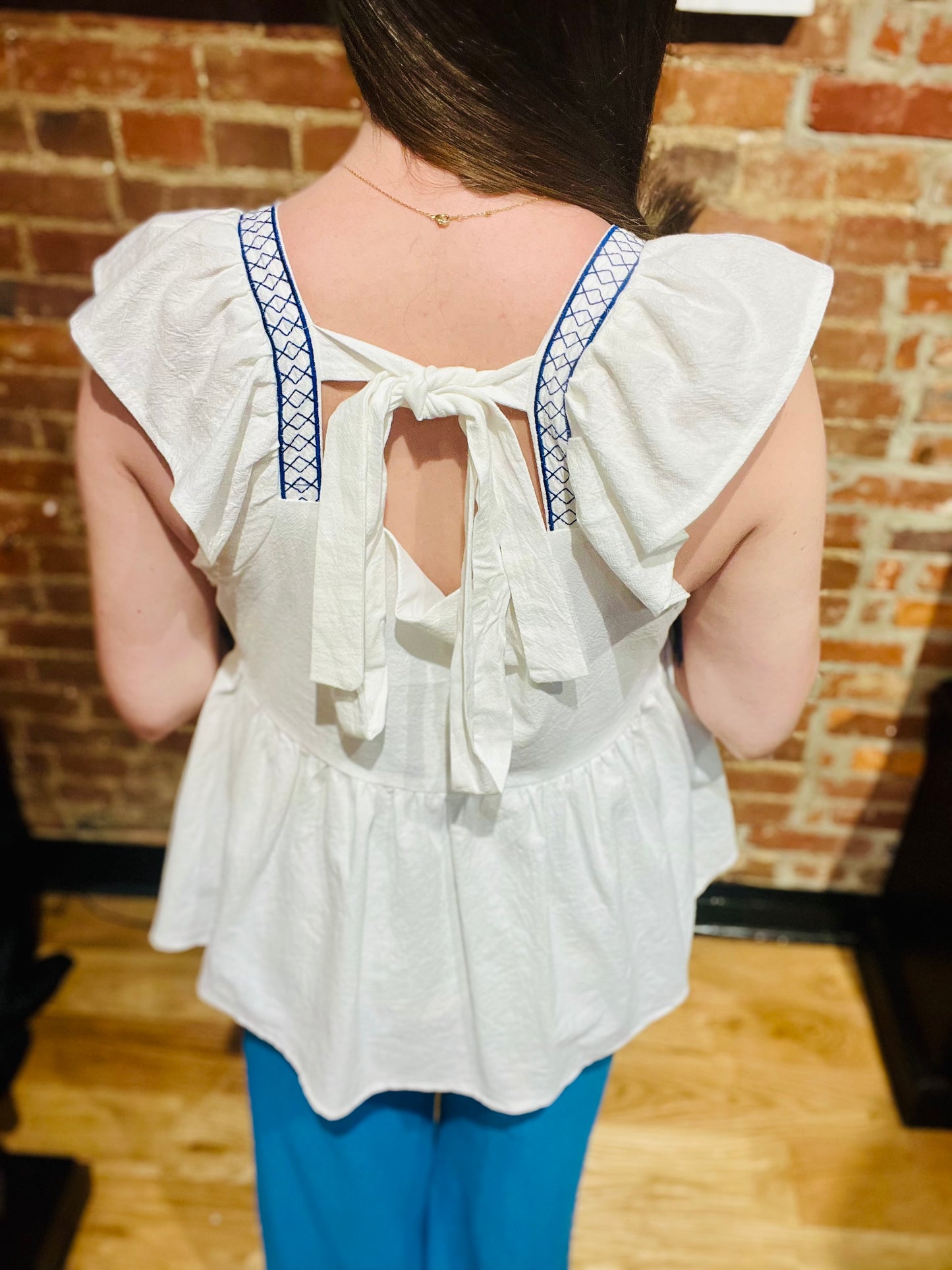 White Ruffle Sleeve Flowy Top with Blue Embroidered Detailing at Bust
