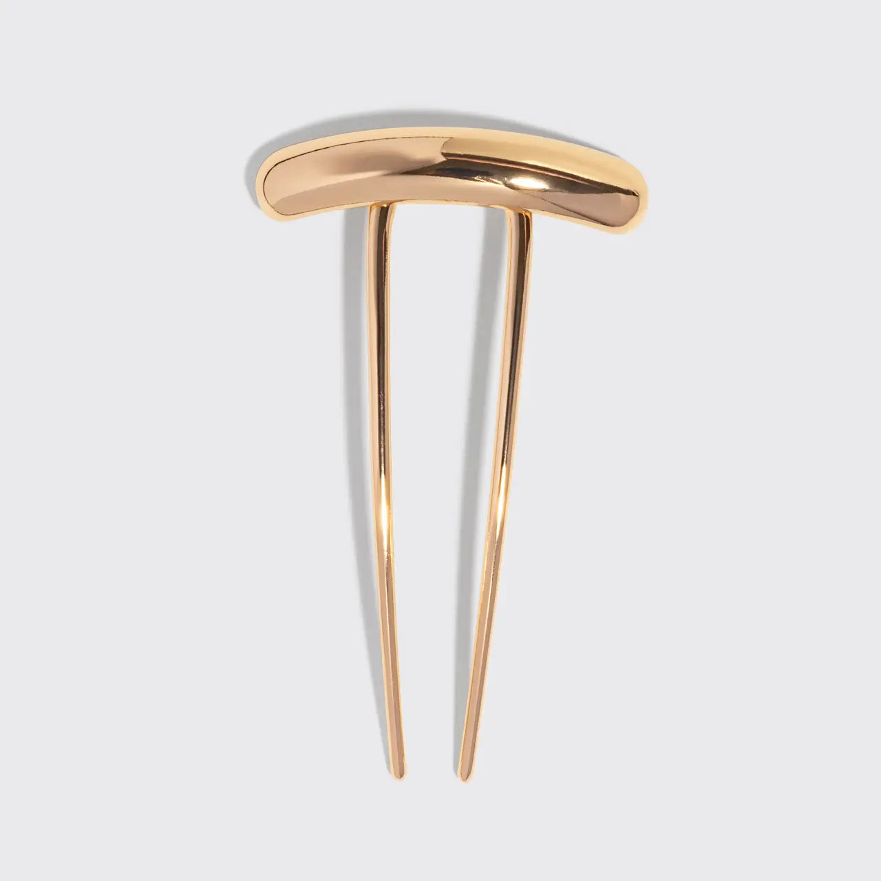 Gold hairpin on a light gray background