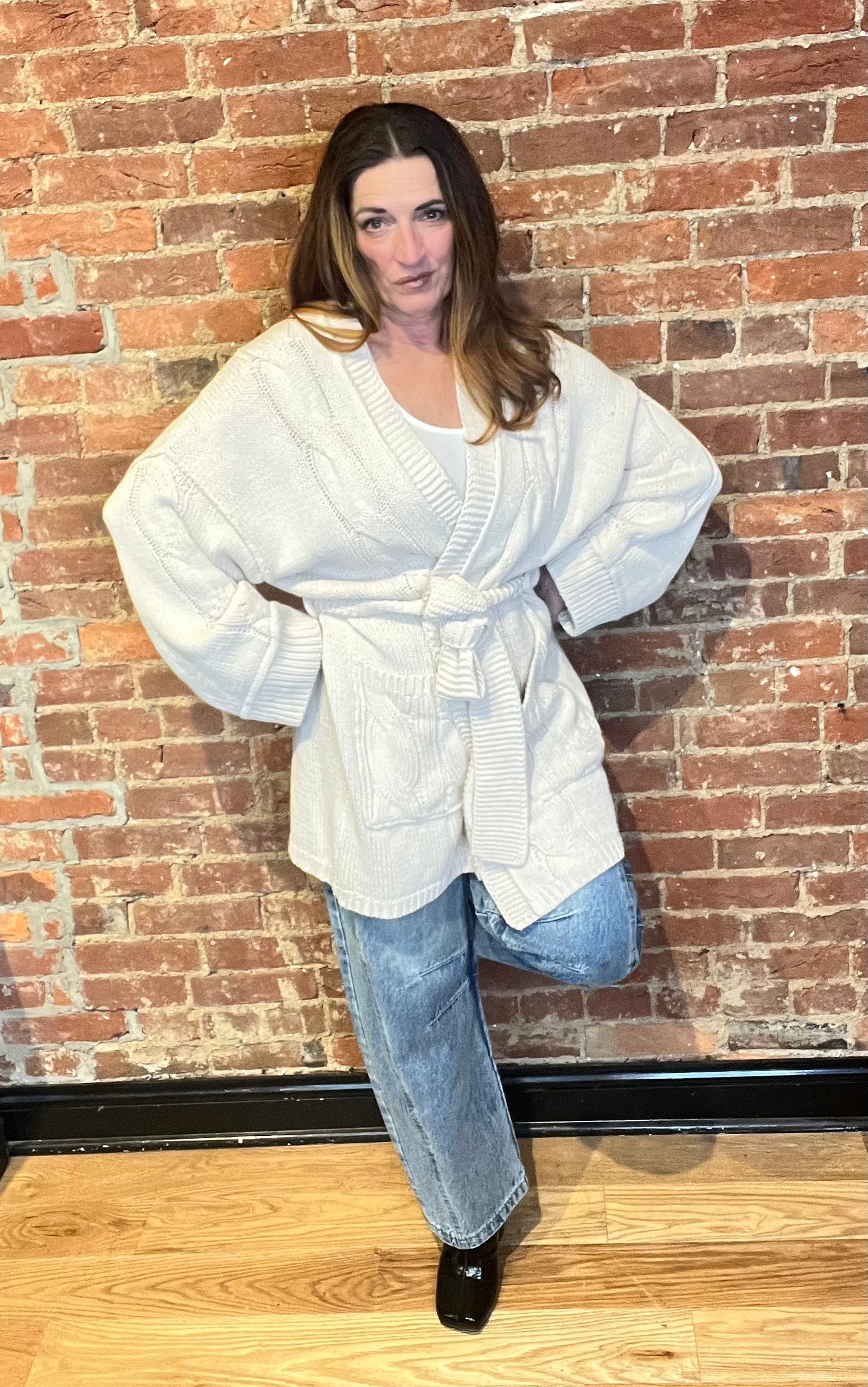 Cream cardigan sweater, relaxed fit, dropped shoulders, long sleeves, open front with waist tie wrap, pockets, kimono silhouette.
