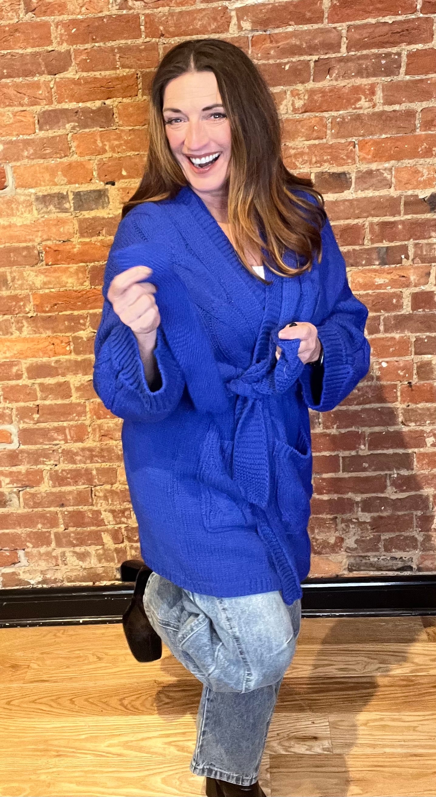Blue cardigan sweater, relaxed fit, dropped shoulders, long sleeves, open front with waist tie wrap, pockets, kimono silhouette.