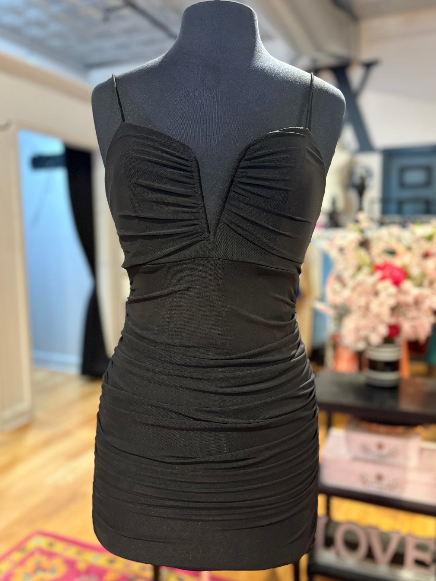 Black v-neck ruched mini dress displayed on a mannequin