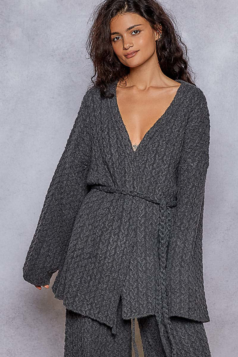 Woman wearing a dark gray textured outfit against a plain background