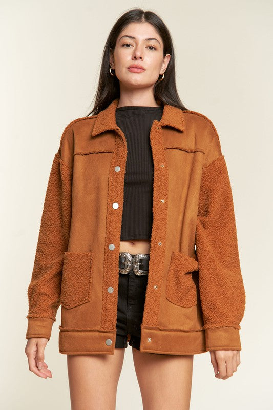 Woman wearing a brown jacket with a plain background