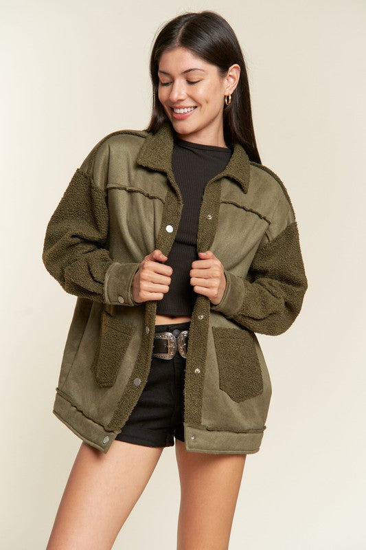 Woman wearing an olive green jacket on a beige background