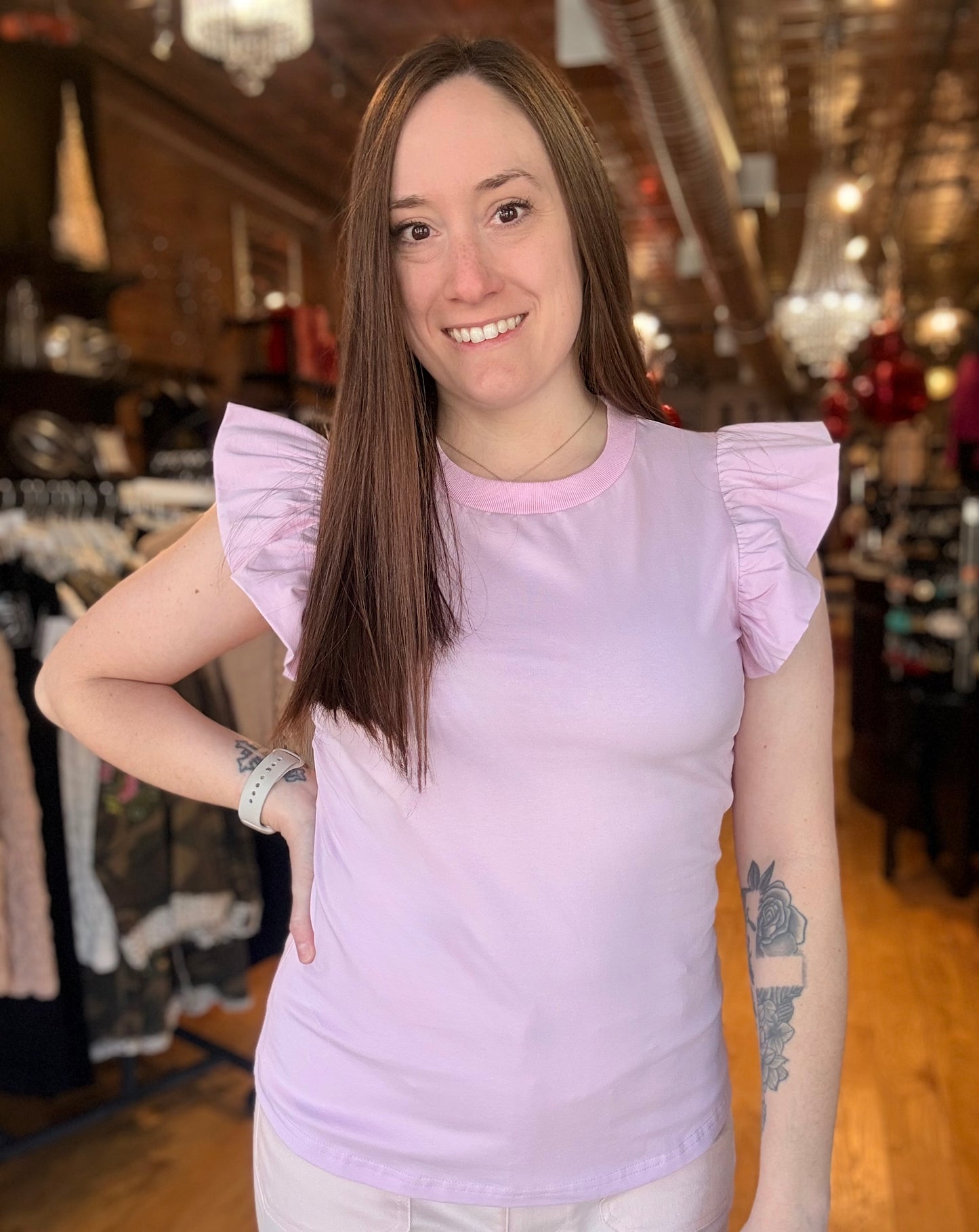 Woman wearing a light purple top in a store setting
