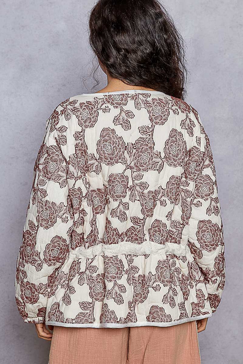 Person wearing a floral blouse with a plain background