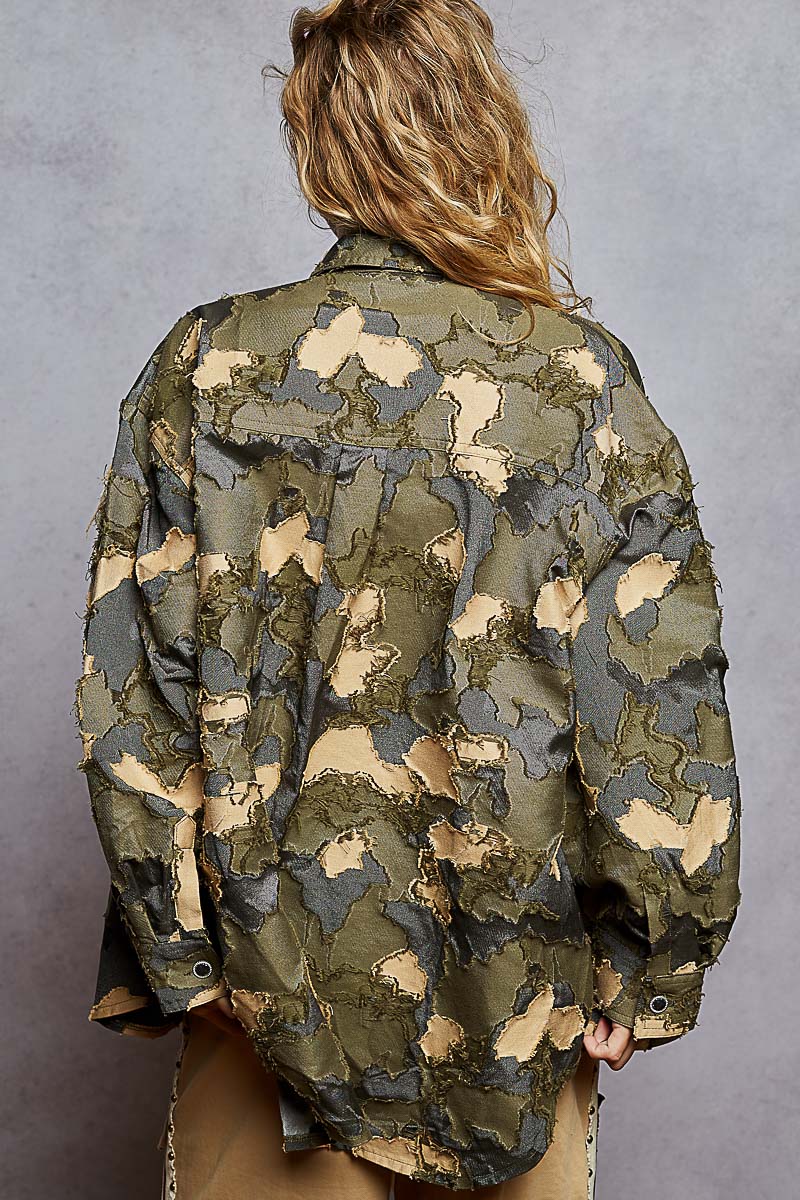 Person wearing a camouflage jacket against a gray background