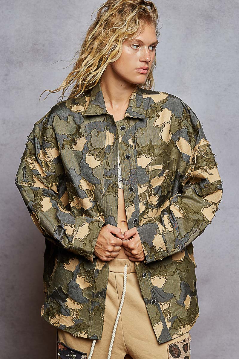 Person wearing a camouflage jacket against a gray background