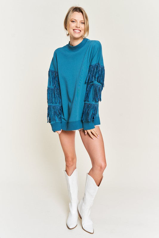 Woman wearing a teal dress with lace details and white boots on a plain background