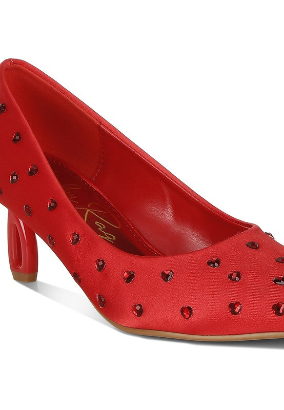Red high-heeled shoe with decorative studs on a white background