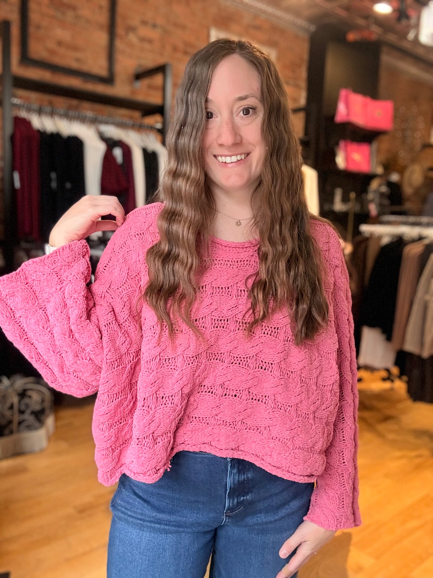 Woman wearing a pink sweater in a clothing store