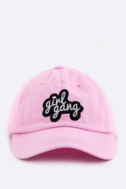 Pink cap with 'girl gang' text on a white background