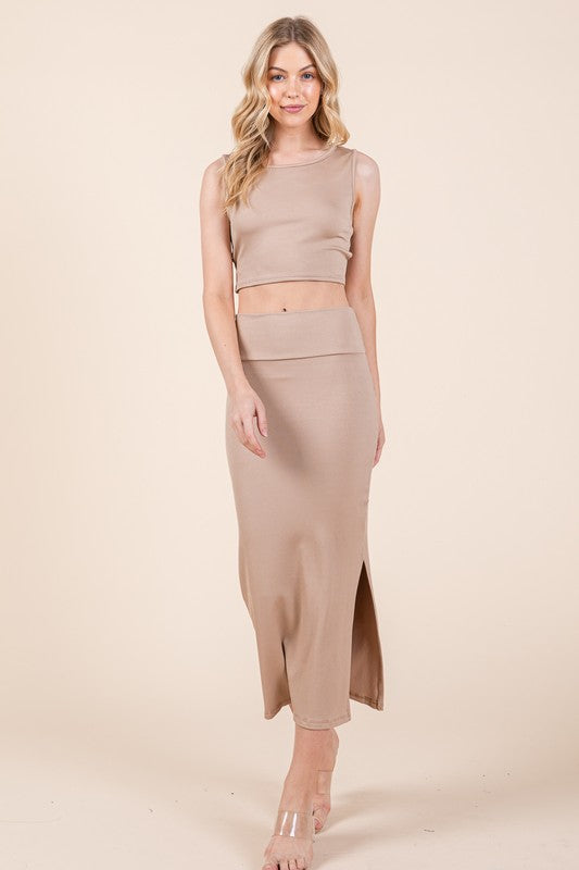 Woman wearing a beige sleeveless top and skirt set on a beige background