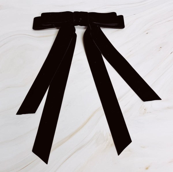 Black ribbon bow on a white wooden surface