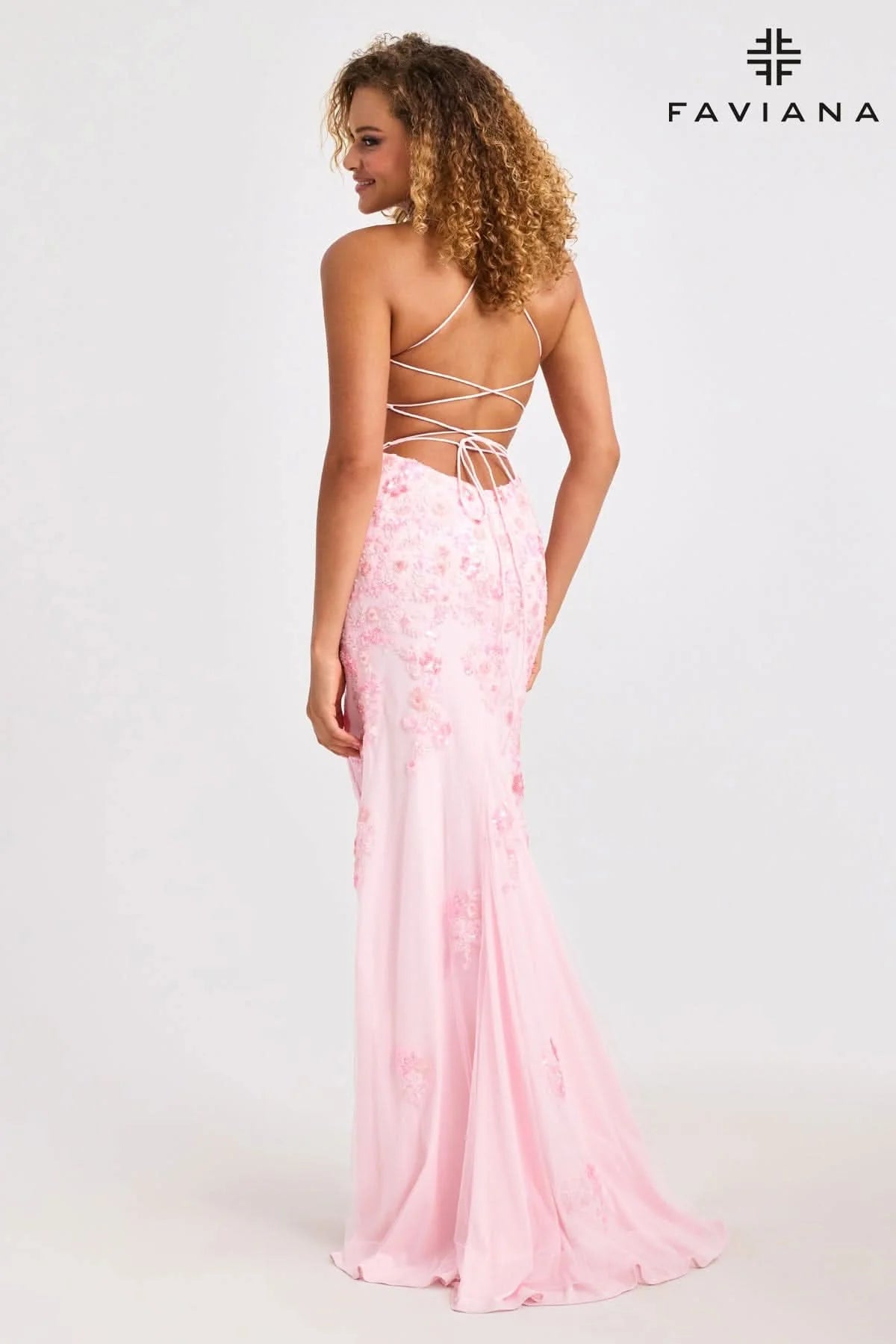 Woman wearing a pink floral dress with a white background and 'Faviana' branding.