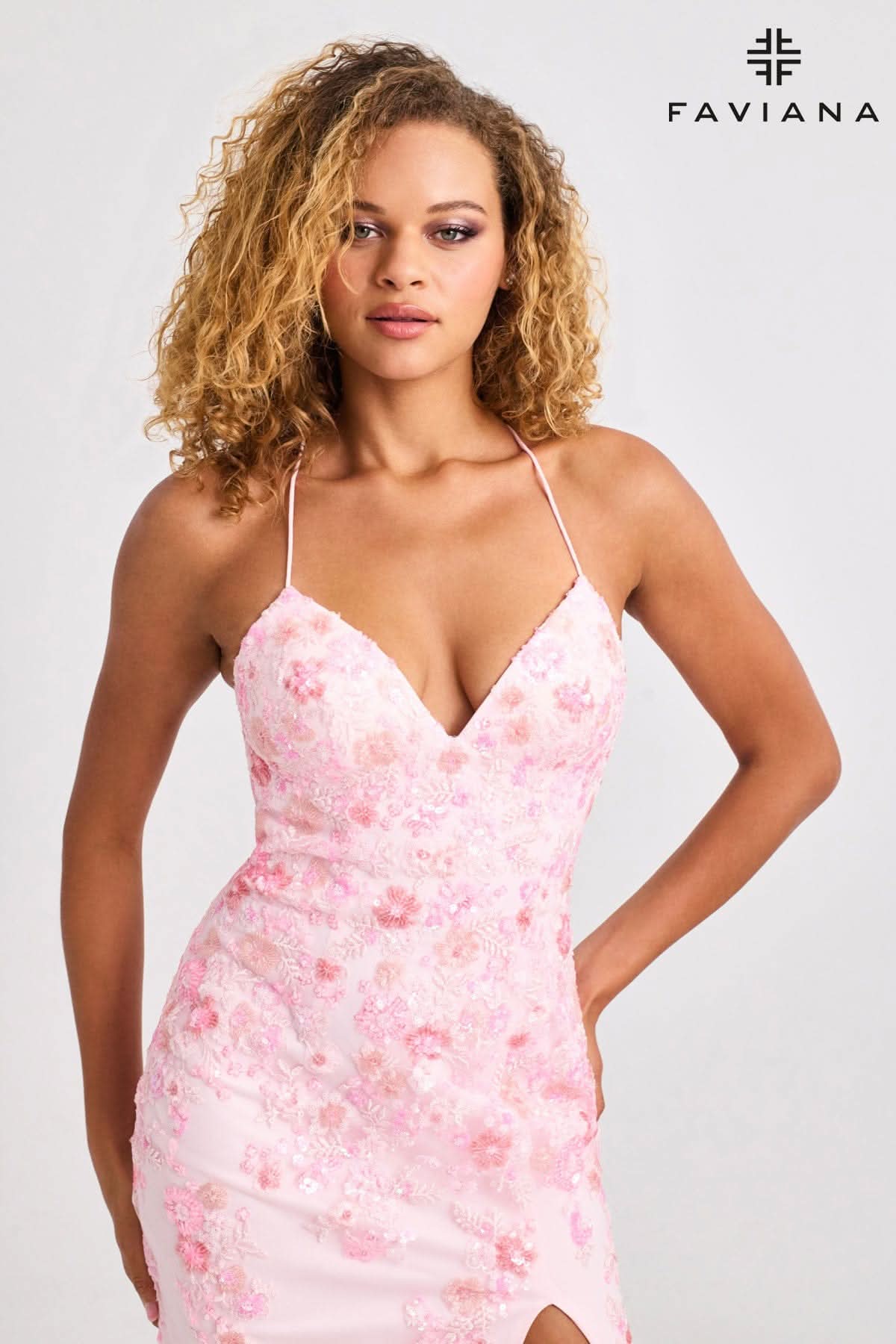 Woman wearing a pink floral dress with Faviana logo above her head