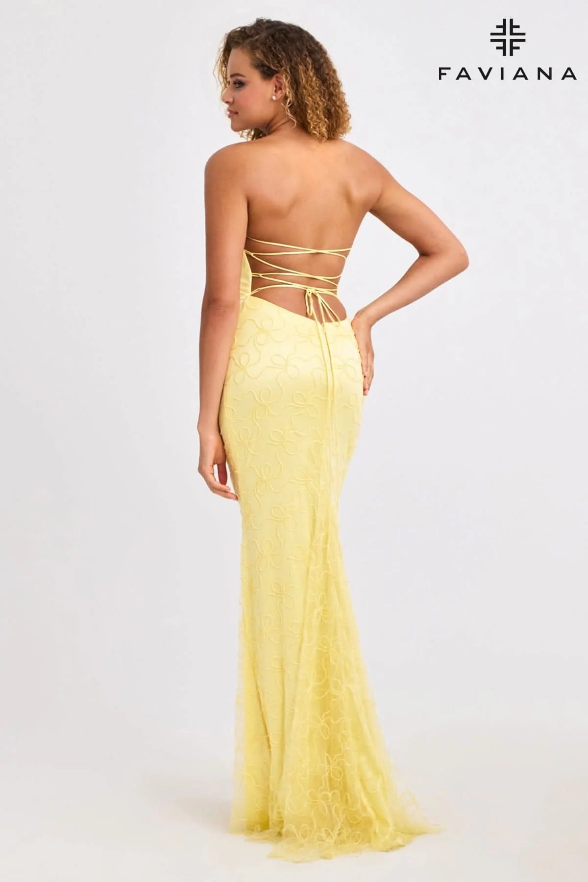 Woman wearing a yellow strapless gown with Faviana branding on a white background